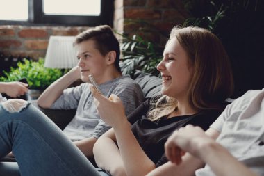 Eğleniyor ve akıllı telefonlar evde kullanma genç grup
