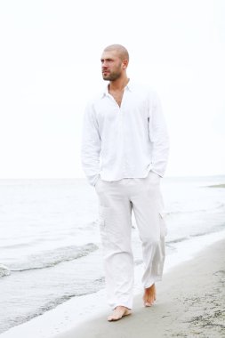 Sahilde çekici ve mutlu bir adam.