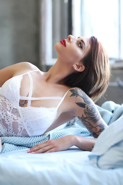 Güzel kız yatakta poz veriyor.