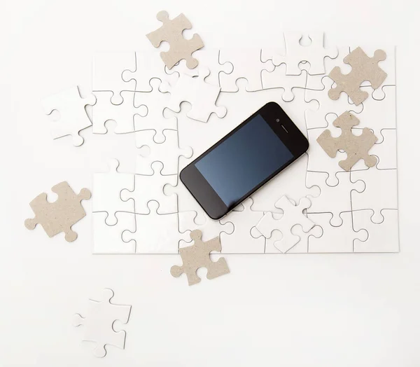 Białe Puzzle Telefonem Komórkowym Stole — Zdjęcie stockowe
