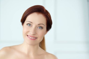 Kızıl saçlı güzel bir kadının yakın plan portresi.