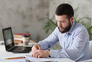 Ofiste çalışan yakışıklı genç bir işadamı.