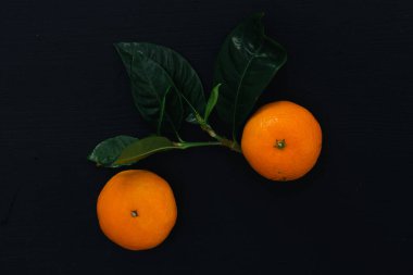 Siyah arka planda bir yığın mandalina.