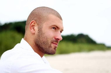 Sahilde çekici ve mutlu bir adam.