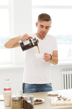 İç, günaydın. Elinde kahve fincanı olan genç adam.