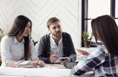 İş kadınları ve işadamları ofiste proje üzerinde çalışıyorlar
