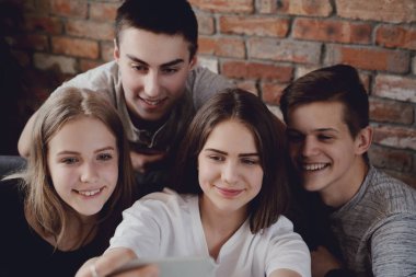 Eğleniyor ve akıllı telefonlar evde kullanma genç grup