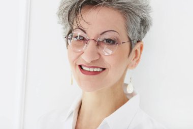 Güzel gülüşü olan tatlı, yaşlı bir kadın.