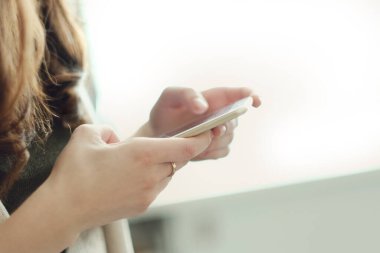 Akıllı telefonu yakın planda tutan kadın.