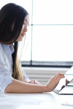 Ofiste çalışan genç Asyalı kadın.