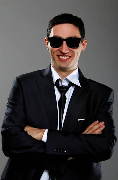 灰色の背景を背景にサングラスの幸せなビジネスマン — ストック写真