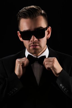 Siyah takım elbiseli çekici bir adam ve kelebek.