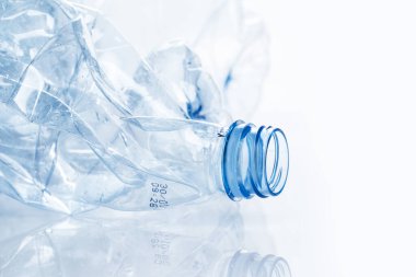 Yararlanma. Boş, ezilmiş su şişesi beyaz arka planda