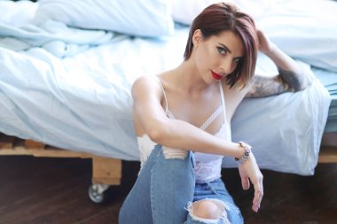 Güzel kız yerde poz veriyor.