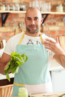 Mutfak. Mutfakta mavi önlüklü bir adam.