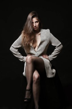 Gri ceketli ve siyah taytlı seksi kadın.