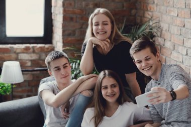 Eğleniyor ve akıllı telefonlar evde kullanma genç grup