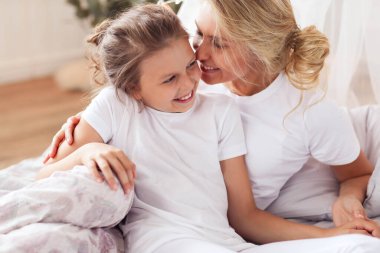 - Aile. Anne ve kızı yatakta.