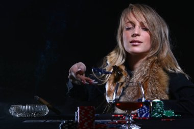 Güzel seksi kadın poker oynuyor ve puro içiyor.
