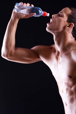 siyah arka plan üzerine soğuk su şişe ile genç adam