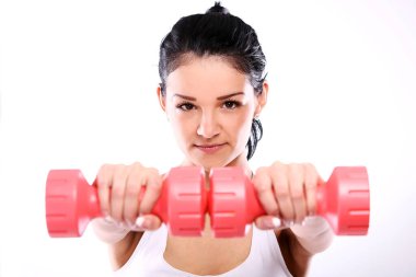 Tatlı ve genç bir kız beyaz arka planda egzersiz yapıyor.