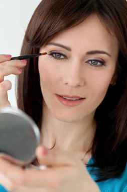 Makyaj yaparken sevimli, çekici bir kadın.