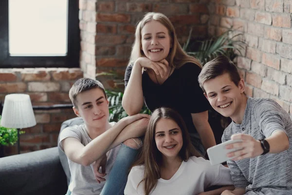 Eğleniyor ve akıllı telefonlar evde kullanma genç grup