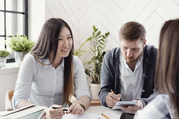 İş kadınları ve işadamları ofiste proje üzerinde çalışıyorlar