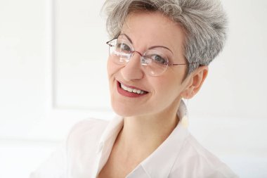 Güzel gülüşü olan tatlı, yaşlı bir kadın.