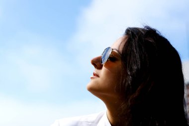 Genç ve güzel bir kadın gökyüzüne bakıyor.
