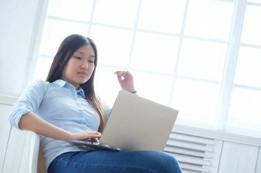 Evde dizüstü bilgisayarı olan bir kadın