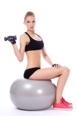 güzel bir kadın fitness Ball dumbells ile beyaz arka plan yapıyor
