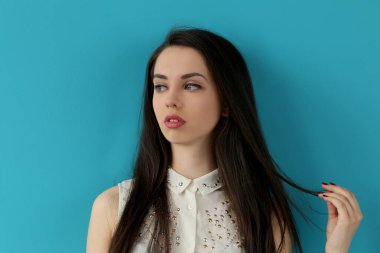 Mavi arka planda sevimli, çekici bir kadın.