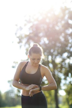 Parkta spor yapan genç bir kadın.