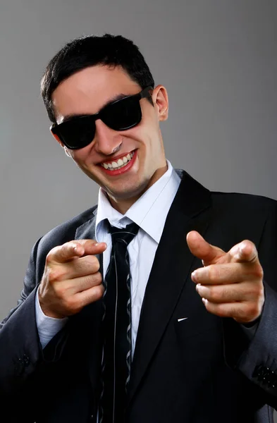 Happy Businessman Sunglasses Gray Background Pointing You — Stock Photo, Image