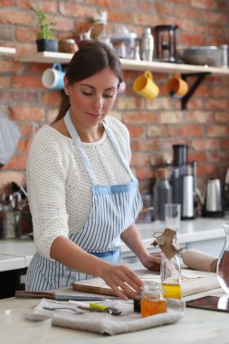 Genç ve güzel bir kadın mutfakta yemek pişiriyor. El yapımı yemek.
