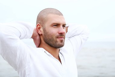 Sahilde çekici ve mutlu bir adam.