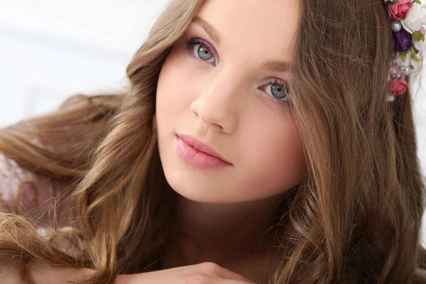 Kafasında çiçekler olan tatlı, genç bir kız.