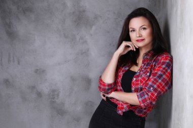 Beton duvarda poz veren güzel bir kadın.