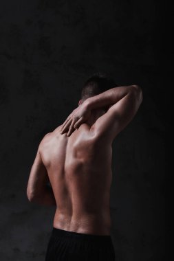 Beton duvarda gömleksiz bir adam.