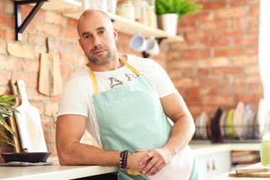 Mutfak. Mutfakta mavi önlüklü bir adam.