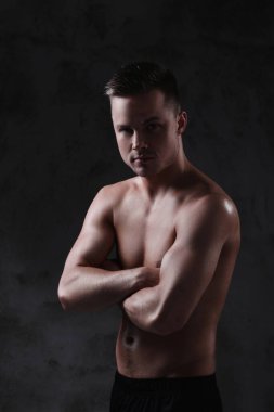 Beton duvarda gömleksiz bir adam.