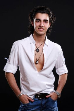 Siyah arka planda izole edilmiş genç ve çekici Latin çocuk.