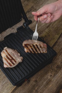 Yemek, yemek. Izgarada biftekli bir adam.