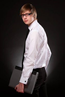 Karanlık arka planda genç ve çekici iş adamı