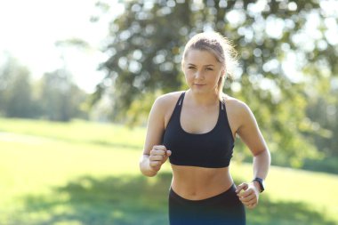 Parkta spor yapan genç bir kadın.