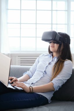 Evde VR kulaklıklı bir kadın var.