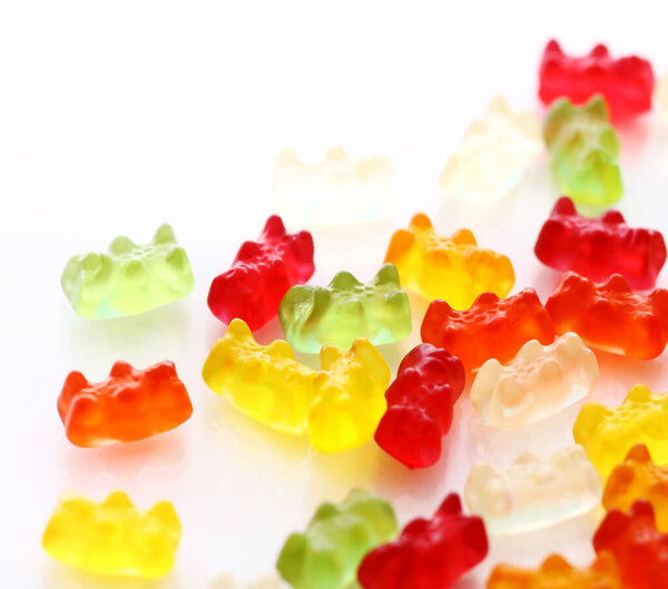 Colorful gummy bear candies over white background