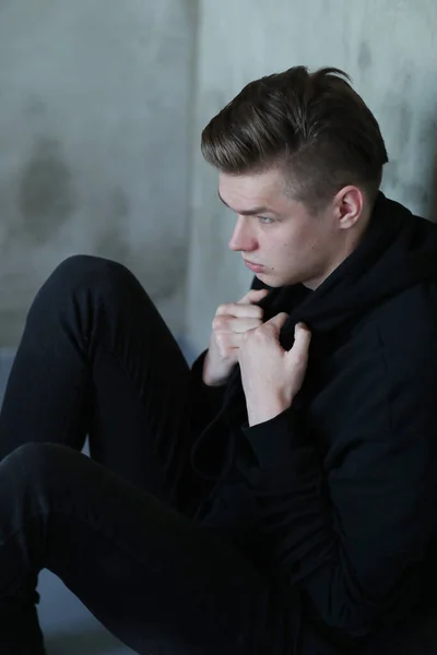 ファッションと流行 黒服のハンサムな男ポーズ上の灰色の壁の背景 — ストック写真