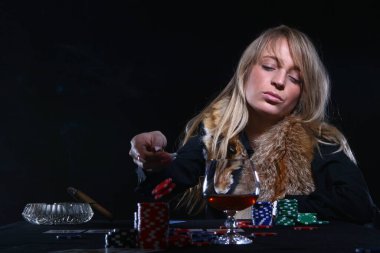 Güzel seksi kadın poker oynuyor ve puro içiyor.